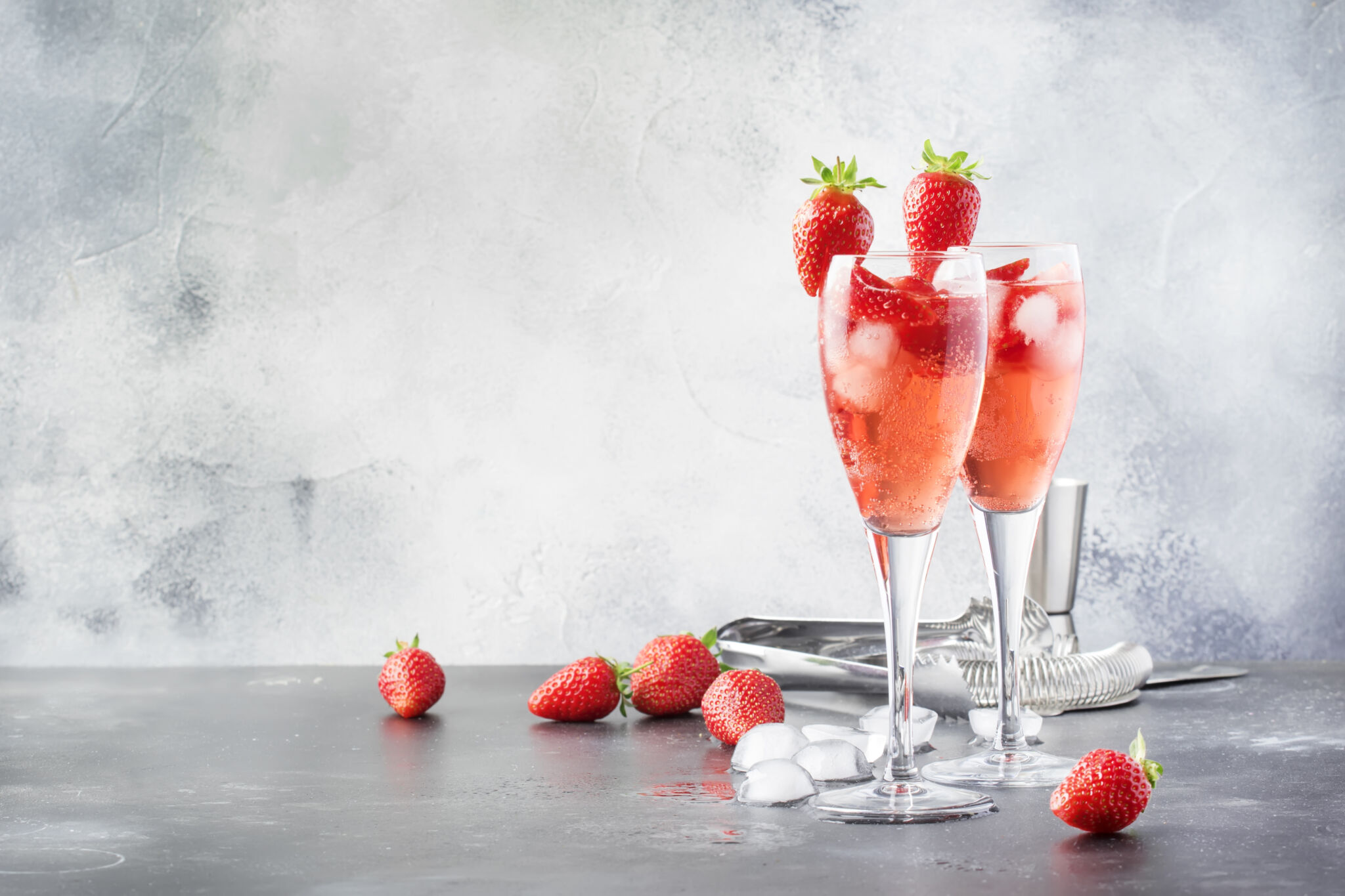 Rossini alcoholic cocktail with Italian sparkling wine, strawberry puree and ice in champagne glasses, place for text, selective focus Rossini alcoholic cocktail with Italian sparkling wine, strawberry puree and ice in champagne glasses, place for text, selective focus